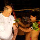 Yanomamienes leder fester arapapegøyefjær på armen til Kong Harald like før avreise - en særskilt hedersbetegnelse (Foto: Rainforest Foundation Norway / ISA Brazil)